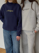 models wearing one dna michigan script mock necks, one navy and one gray, standing against a gray background