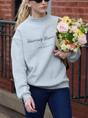 a women is walking in a university flower shop mock neck sweatshirt and carries flowers