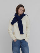 A women wears cable knit sweaters in cream and navy
