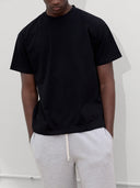 close up of male model wearing black tshirt and heather gray sweatpants by one dna
