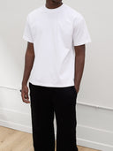 close up of male model wearing white tshirt and black sweatpants by one dna clothing