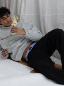 Male model holding a flower wearing University Flower Shop Ann Arbor mock neck sweatshirt