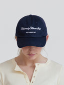 Person wearing navy hat with University Flower Shop Ann Arbor MI embroidered in white